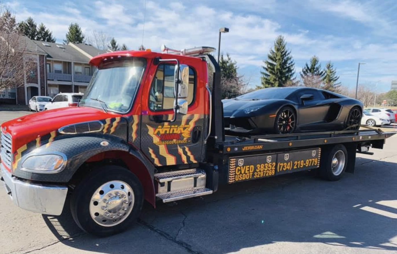 ARNAZ Towing red flatbed tow truck hauling a sports car